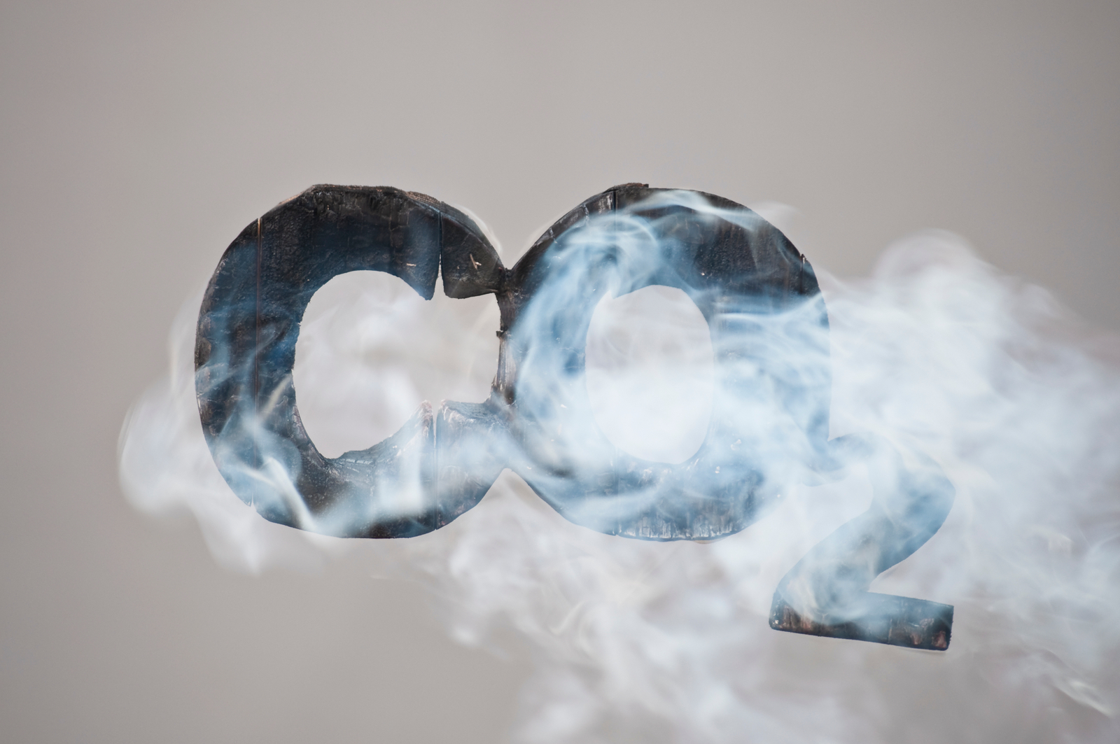 Teksten CO2 i sort som det ryker av. Grafisk illustrasjon.