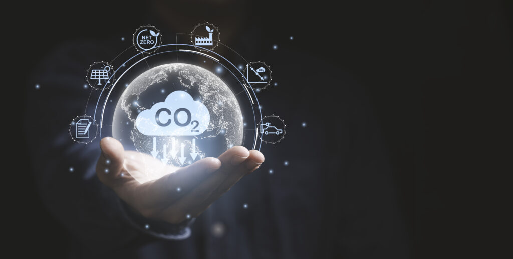 En hånd holder et CO2-reduserende symbol. Foto med grafikk.