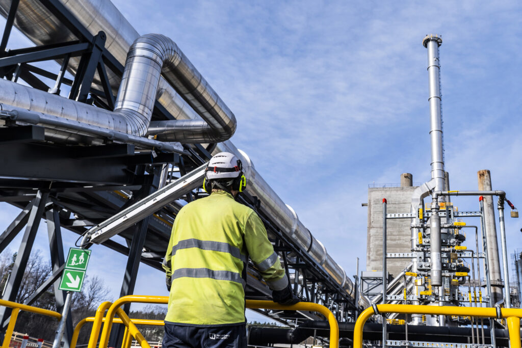 Man looking out over an industrial plant. Photo