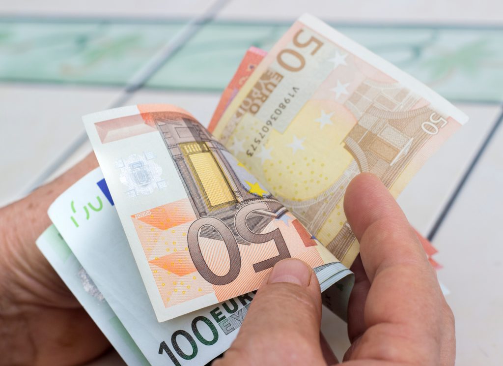 En hånd som holder pengesedler, Euro, i hånden. Foto.